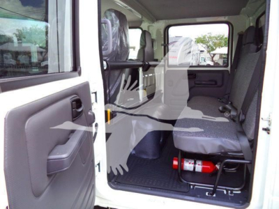 Isuzu NPR HD cab interior showing front passenger seat and extended rear seating area with fire extinguisher under seat.