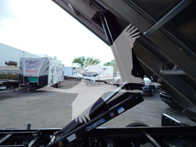 Isuzu NPR-HD dump truck bed support hydraulic cylinder with Champon branding visible, part of a dump truck frame.