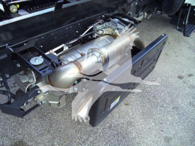 Isuzu NPR-HD engine bay showing exhaust system and chassis components.