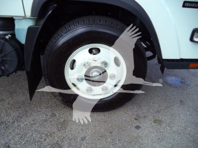 Isuzu NPR HD front wheel showing steel wheel and tire with hub cap and lug nuts.