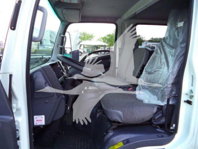 Isuzu NPR-HD truck cab interior showing front seats and steering area with plastic seat covers.