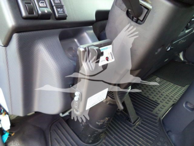Isuzu NPR-HD dashboard area with ignition switch and control panel; visible label on a tethered device and floor mat,” showing interior components.