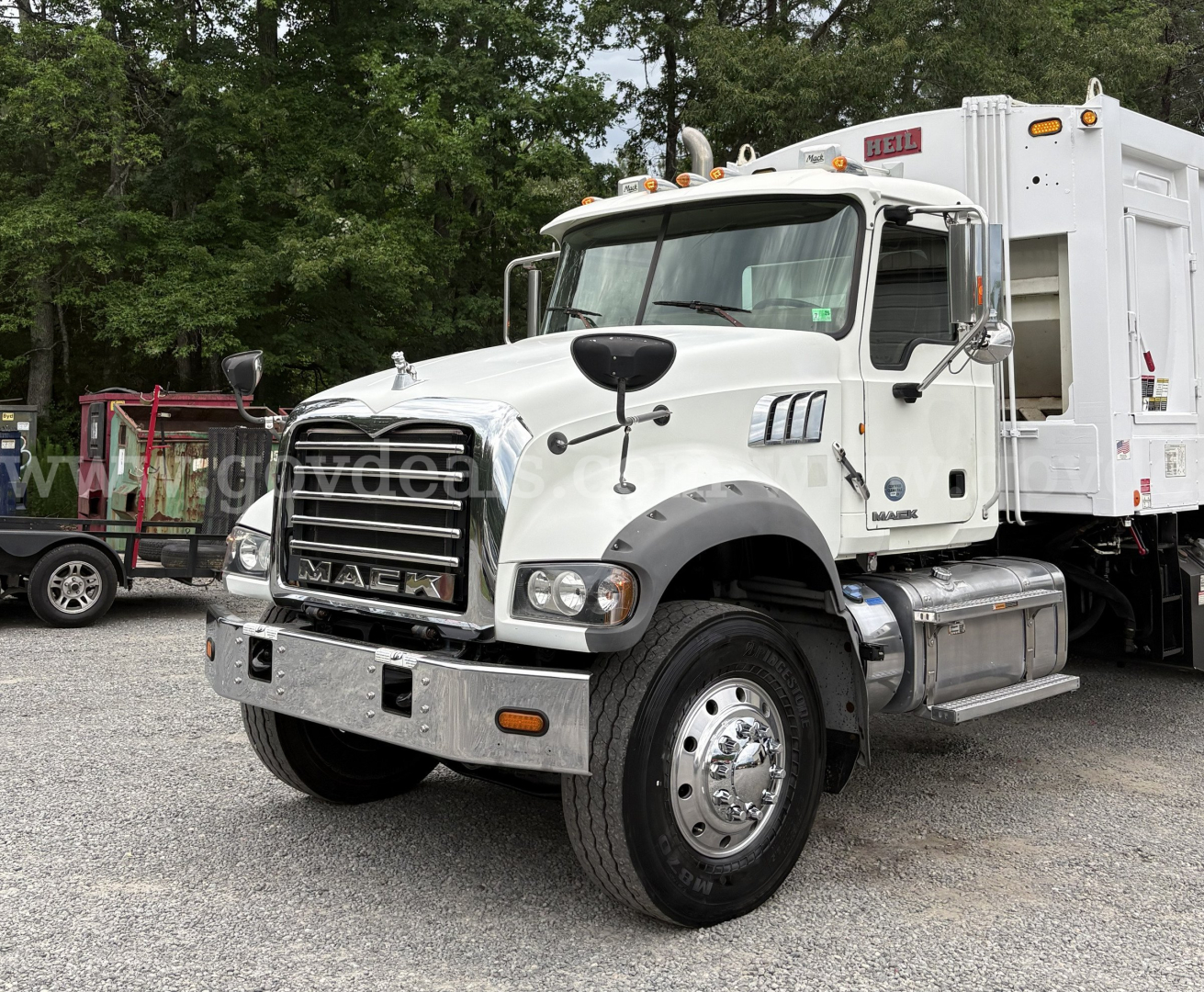 Mack GU713 truck in service showing front grille, cab, and rear dump body with chrome bumper and dual rear wheels.
