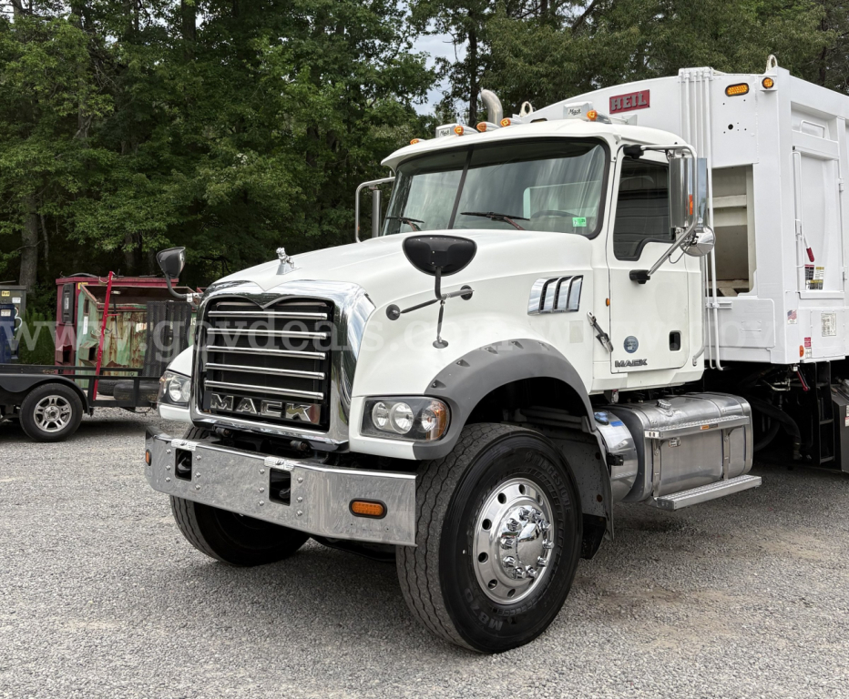 Mack GU713 truck in service showing front grille, cab, and rear dump body with chrome bumper and dual rear wheels.