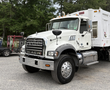 Mack GU713 truck in service showing front grille, cab, and rear dump body with chrome bumper and dual rear wheels.