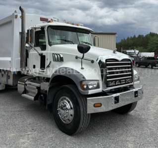Mack GU713 truck in a yard showing front grille and bumper with chrome accents and dual mirrors.