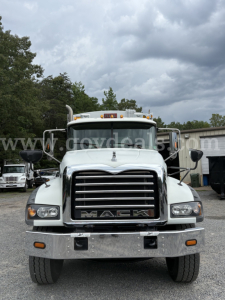Front view of a white 2015 Mack GU713 truck showing chrome grille with MACK lettering, large bumper, headlights, and side mirrors.