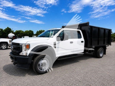 Ford F-450 XL dump truck, white cab, black dump bed, side view showing front grille and wheel.