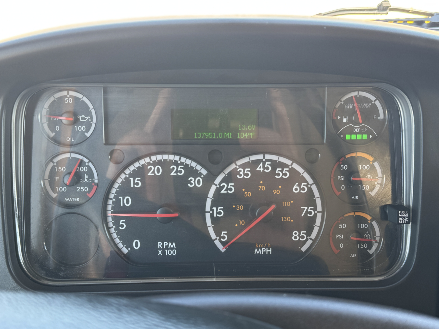 Dashboard of a 2022 Freightliner M2-106 showing analog gauges and digital display.