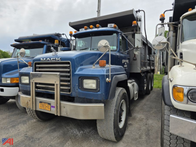 Dump truck front view showing blue Mack RD688S dump truck with chrome bumper and hood, large grille, round mirrors, and yellow clearance lights.