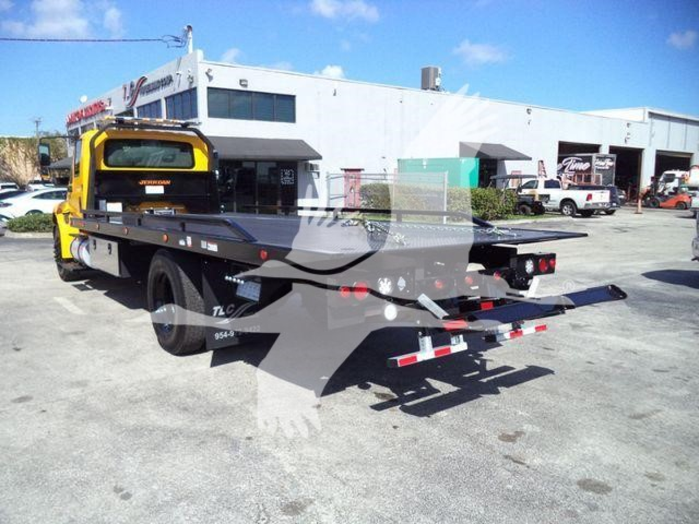 2019 International Durastar 4300 rollback tow truck rear view with flatbed in service.