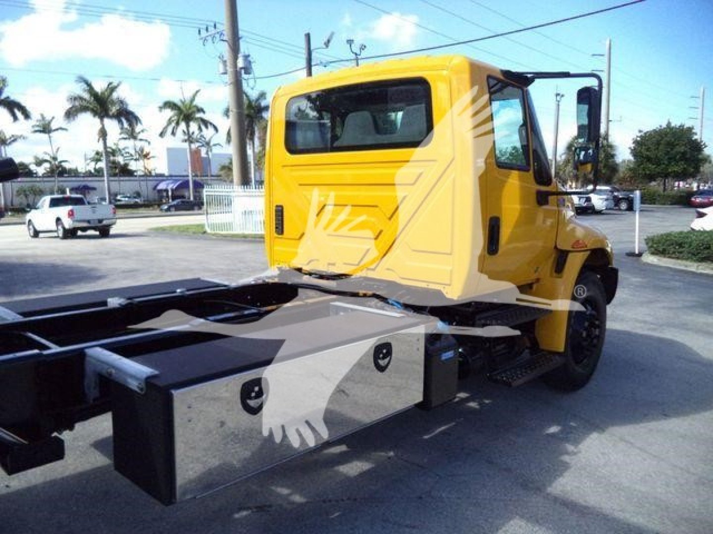 Truck cab and chassis of a 2019 International Durastar 4300 rollback showing rear view of cab and flatbed mounting blocks.