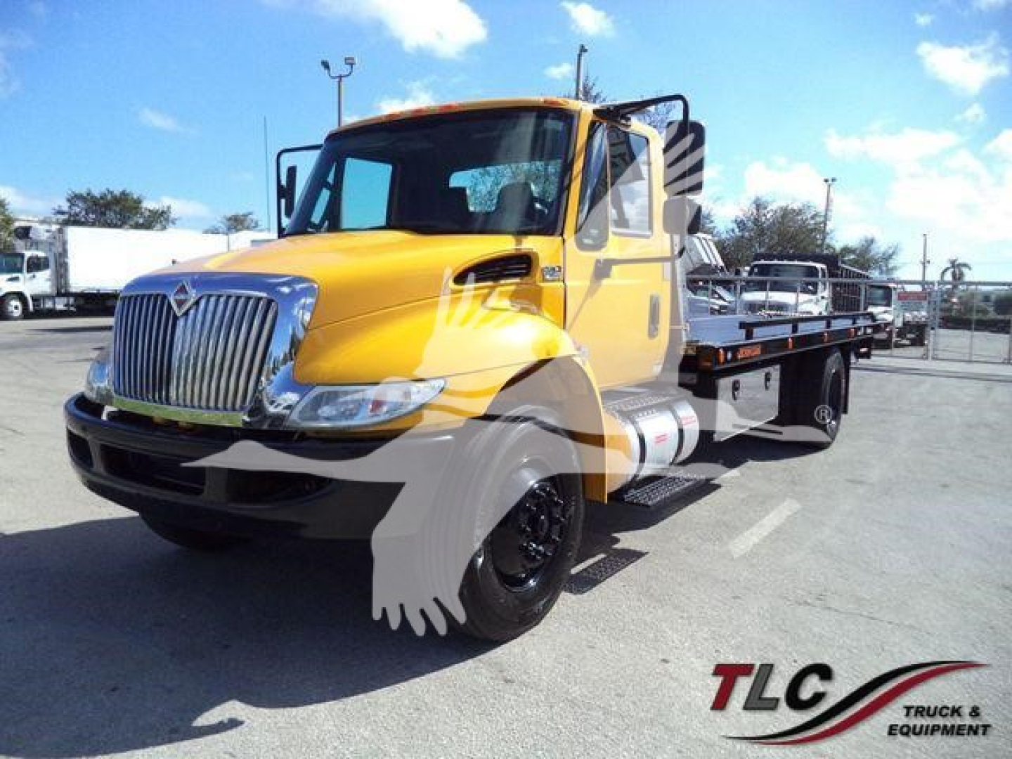 2019 International Durastar 4300 rollback tow truck in yellow with flatbed, front grille, headlights visible