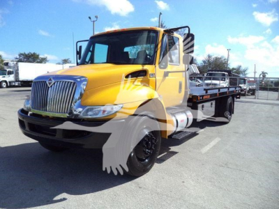 2019 International Durastar 4300 rollback tow truck showing yellow cab and flatbed with black wheels.