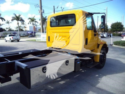 Truck cab and chassis of a 2019 International Durastar 4300 rollback showing rear view of cab and flatbed mounting blocks.
