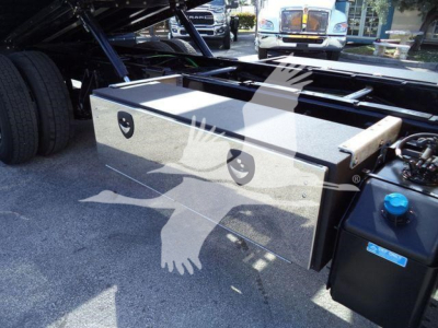 Truck toolbox mounted on chassis with dual lockable drawers and blue coolant reservoir visible near edge.