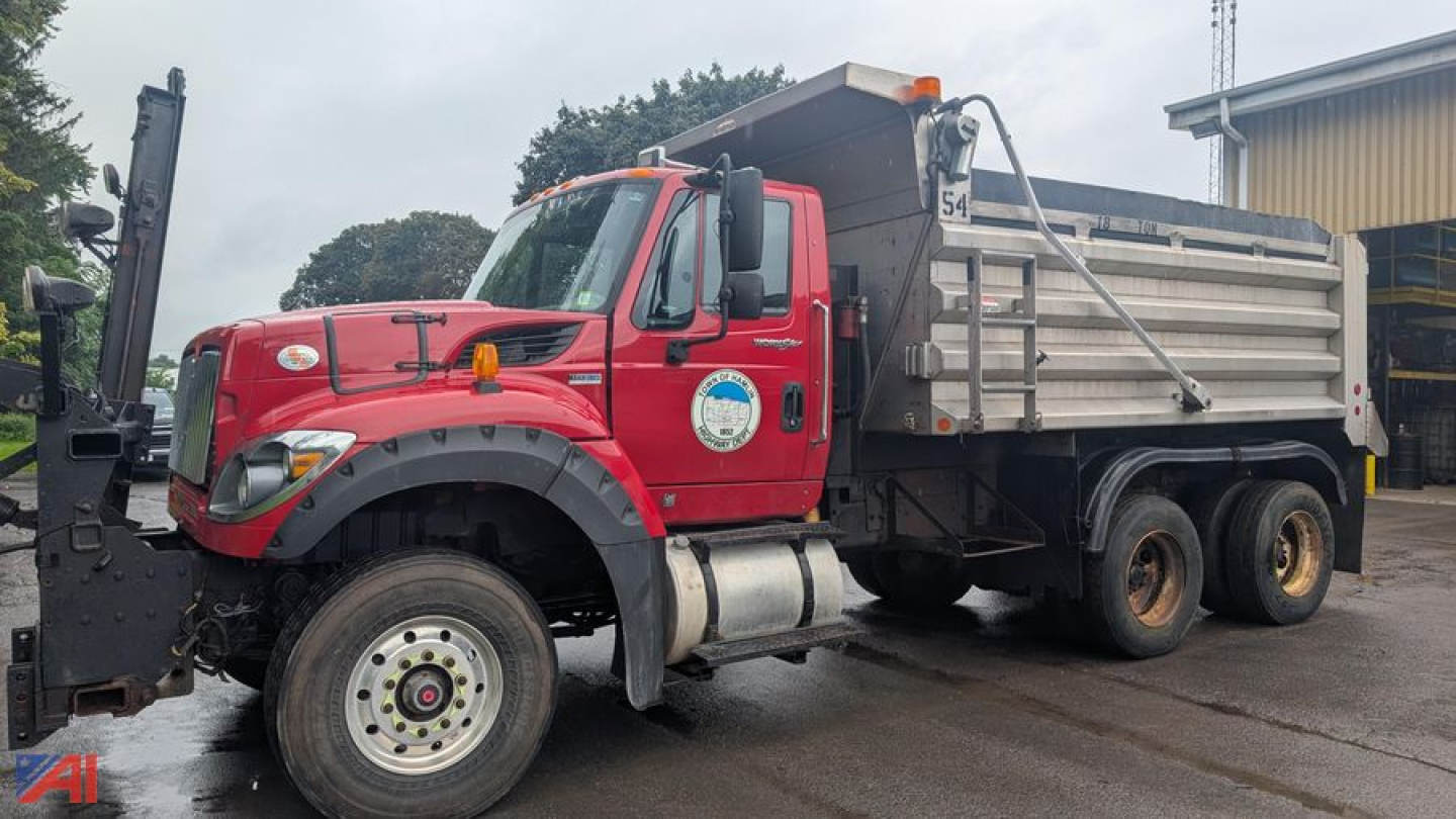 International WorkStar 7600 dump truck with red cab and silver dump body, side view showing front wheel, water tank, and side badge.