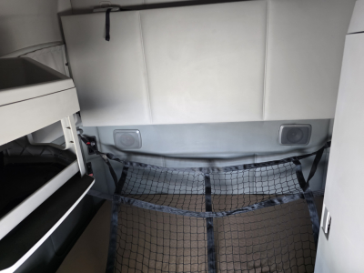 Kenworth T680 sleeper cab interior showing cargo net and storage area behind seats.