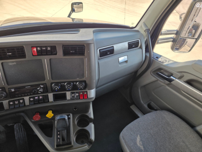 Kenworth T680 truck interior cab dashboard and steering area with controls and cup holders.