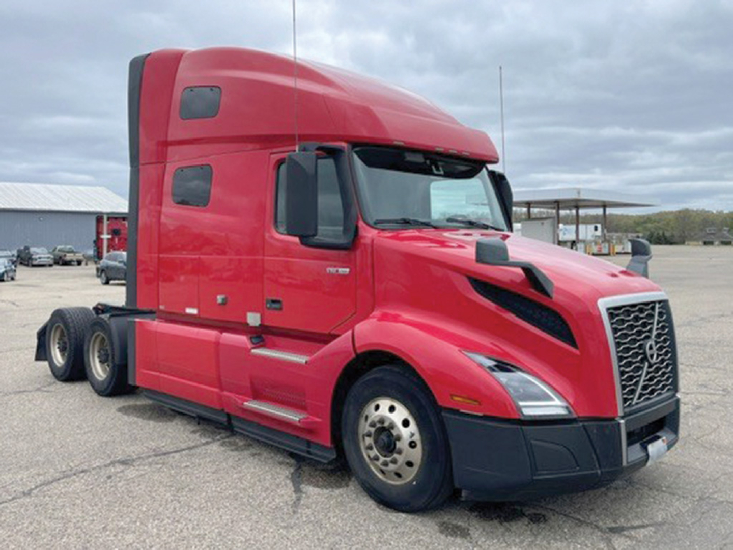 Volvo VNL 760 daytime view showing red sleeper cab and side profile with 6x4 configuration.