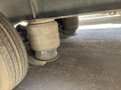 Great Dane steel spread air drop deck trailer showing air ride or suspension components and dual wheels with dust on tires.