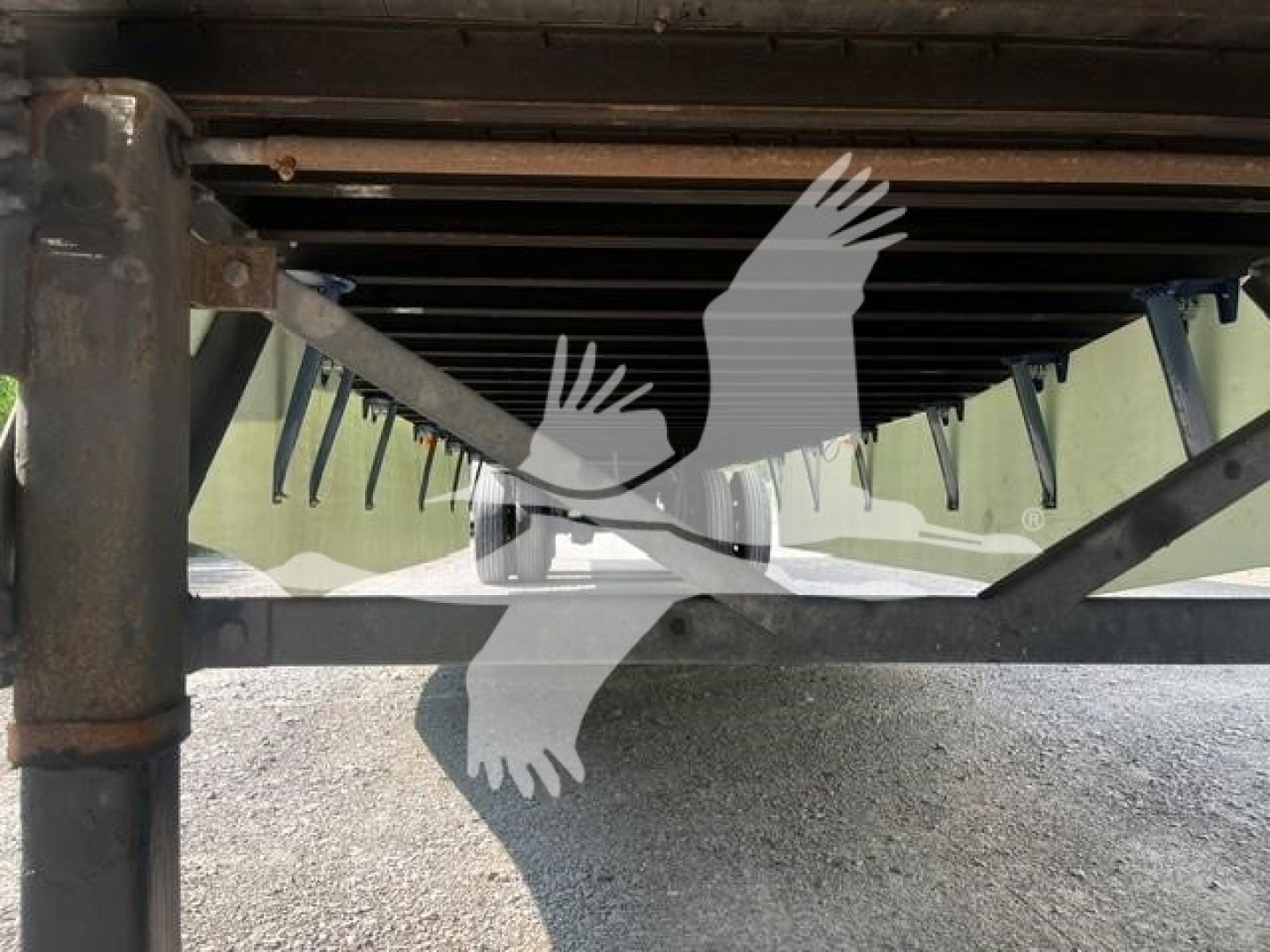 Trailer underside view showing suspension and frame with landing gear and support beams.