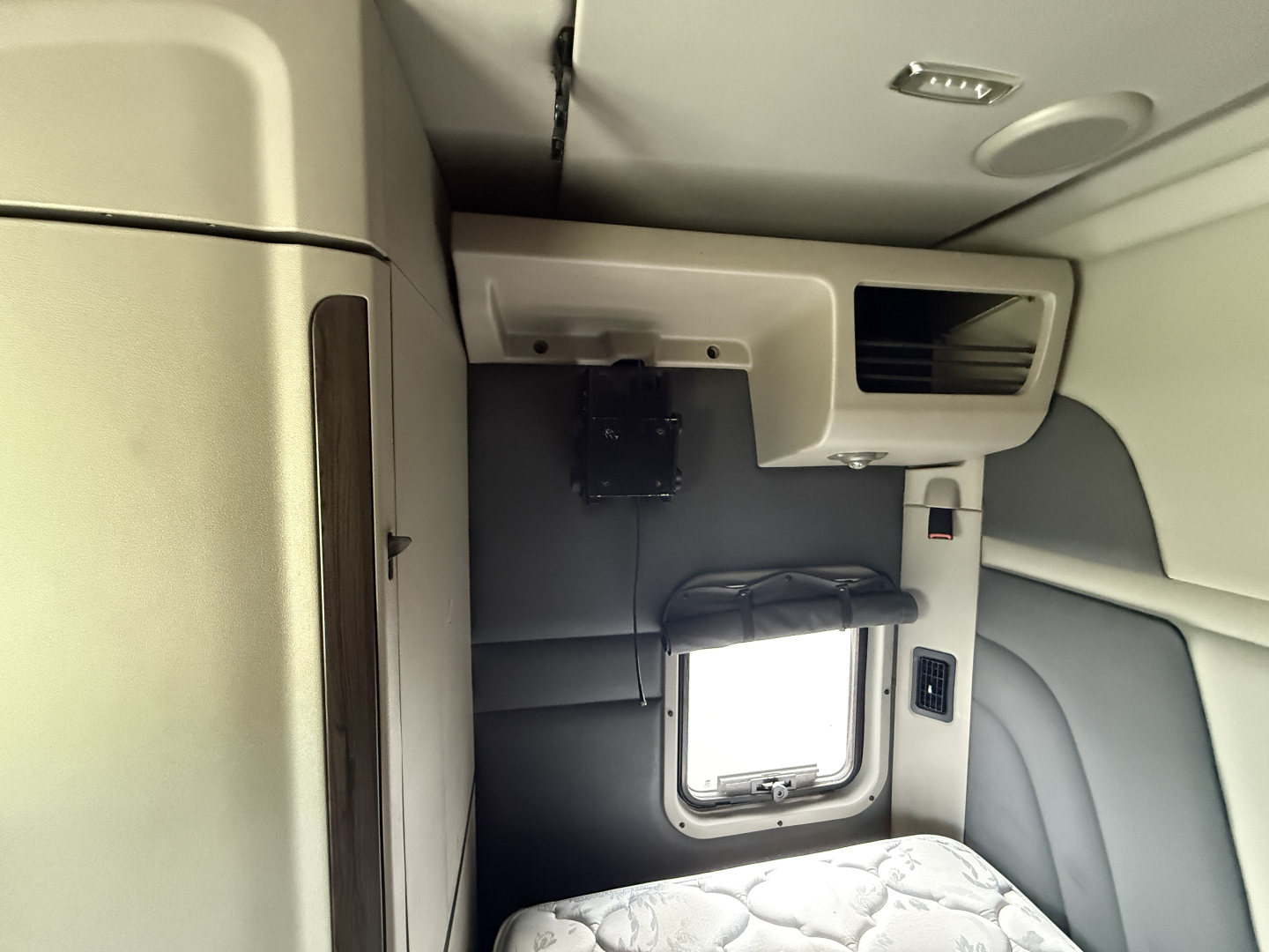 Interior view of a Peterbilt 579 truck cab showing dashboard area with a window and storage compartment.