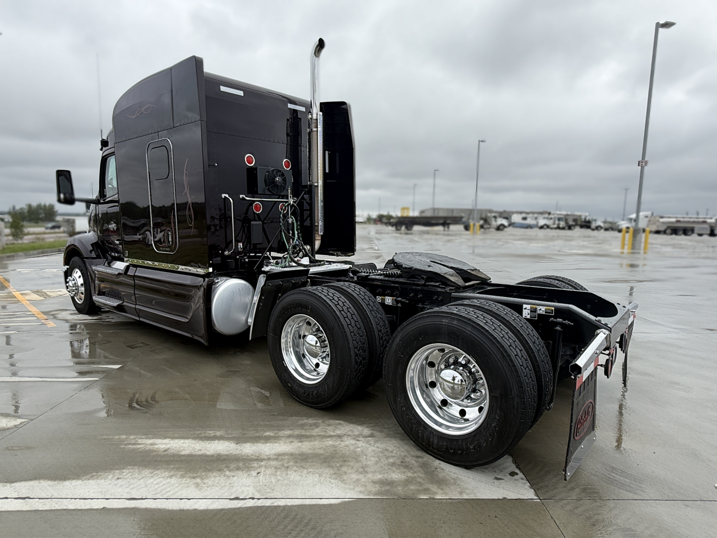Peterbilt 579 tractor chassis view showing rear dual axles and sleeper cab, black exterior, chrome wheels, no trailer attached.