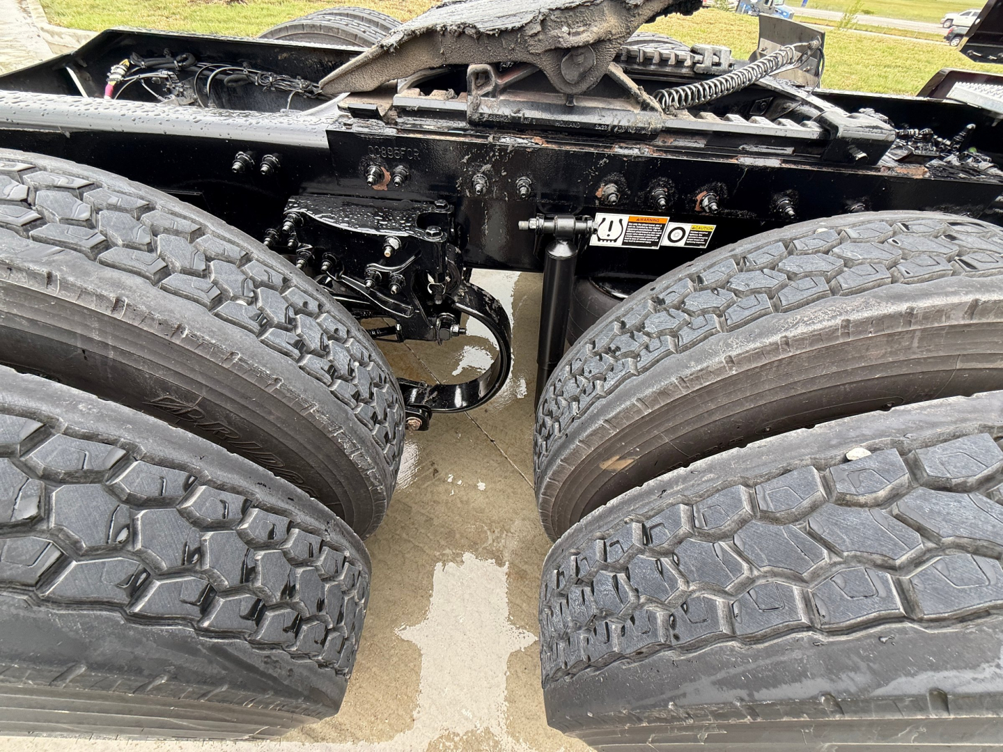 Peterbilt truck chassis showing dual rear axles and tires; undercarriage components and frame visible.