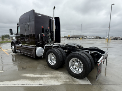 Peterbilt 579 tractor chassis view showing rear dual axles and sleeper cab, black exterior, chrome wheels, no trailer attached.