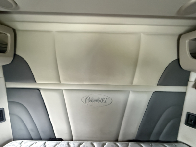 Peterbilt interior headliner and sleeper cab seating area with Peterbilt logo on light-colored upholstery.
