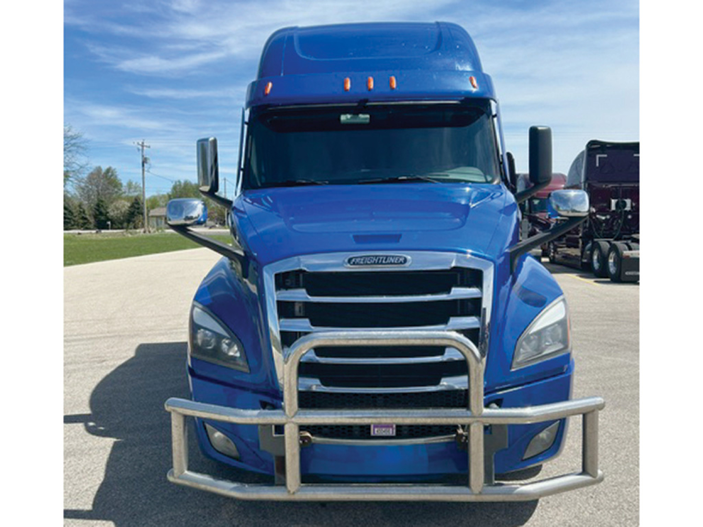 Front view of a blue 2022 Freightliner Cascadia 126 Conventional Sleeper truck with chrome grille guard.