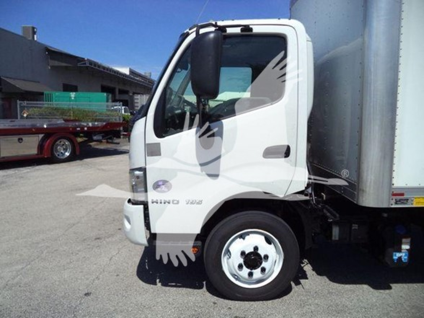 Box truck cab showing 2020 Hino 195 with white exterior and black mirror, side view. VIN JHHRDM2H4LK010445 visible near door, stock T10445.