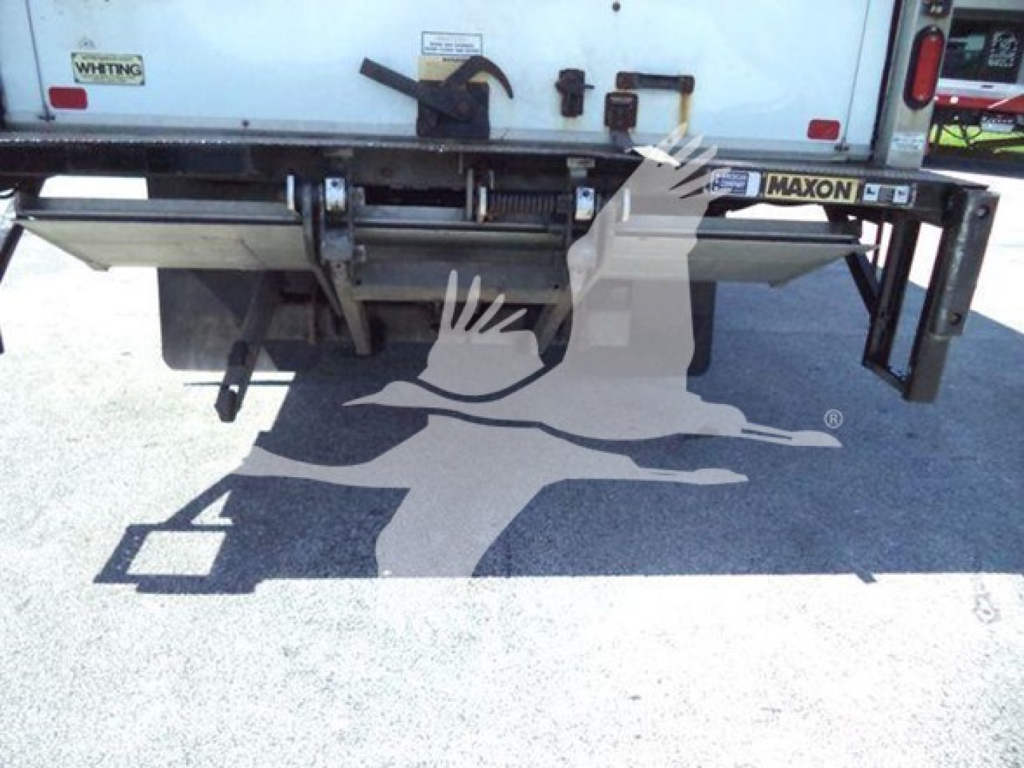 Rear view of a 2020 Hino 195 box truck showing underbody and rear bumper with Maxon liftgate apparatus. Visible stickers and text: MAXON on liftgate.