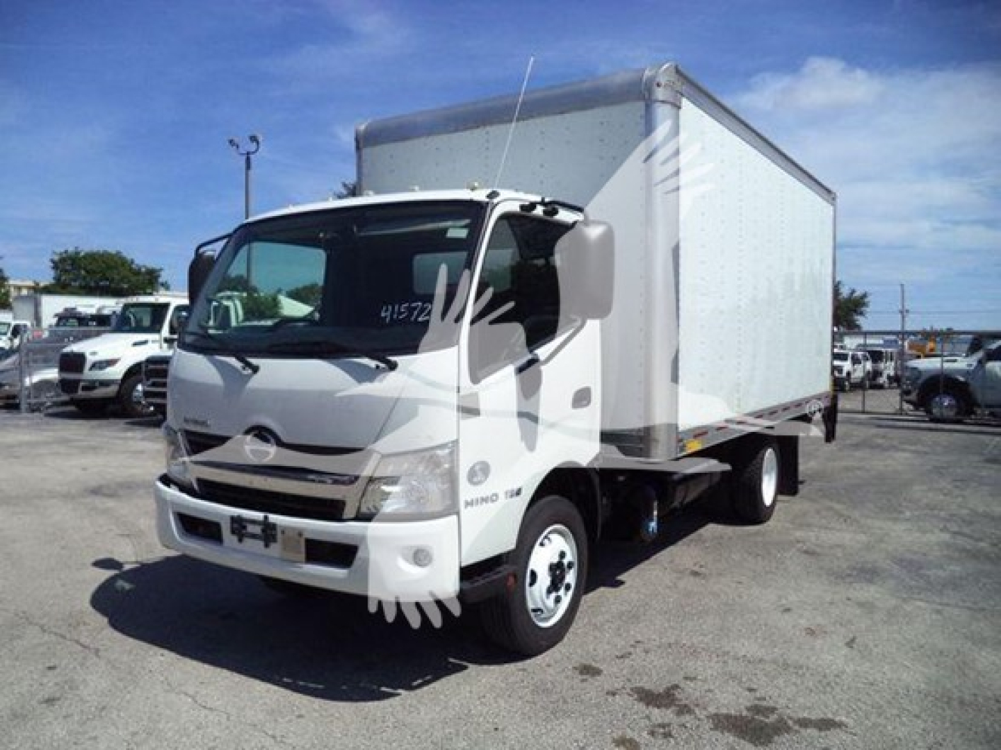 Front-right view of a white 2020 Hino 195 box truck with cab over design. Box cargo area visible. Some text on windshield and side panels, no close-up text readable.