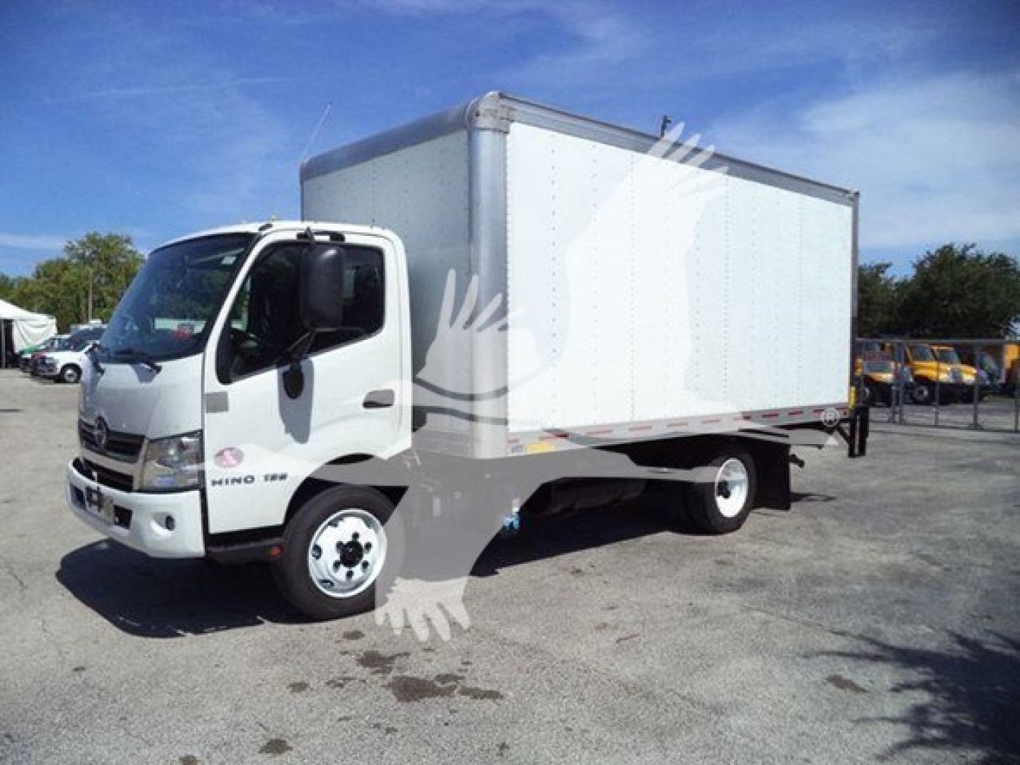 Box trucks with a white cab and a large white box body, Hino logo on the door, side view showing cab and cargo box.