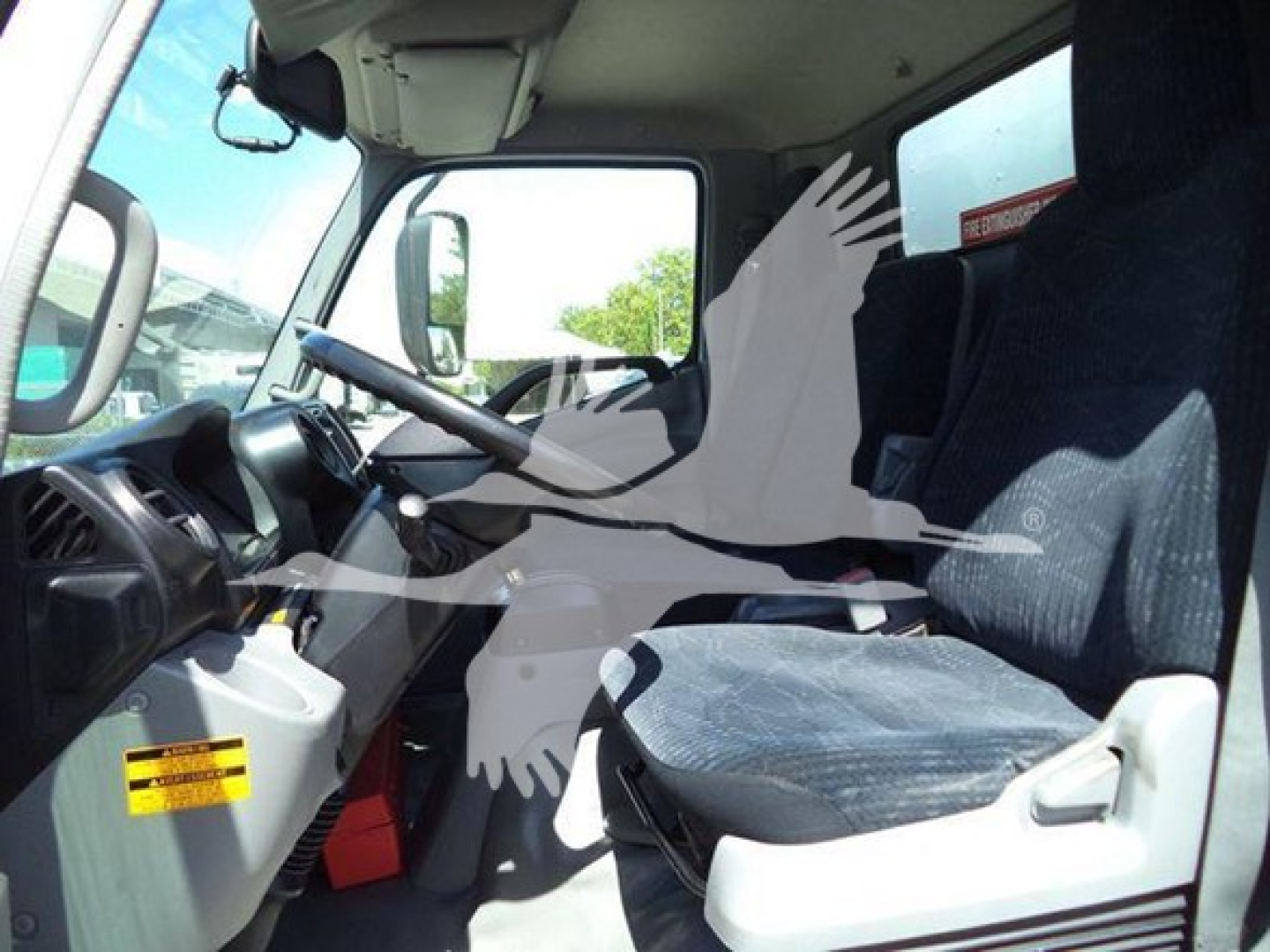 Hino 195 cab interior showing steering wheel, dashboard, driver seat, passenger seat, and window view.