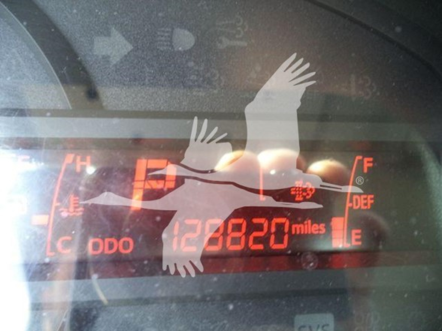 Dashboard display showing odometer 128820 miles with DEF and fuel gauges and Hino branding in the glare.