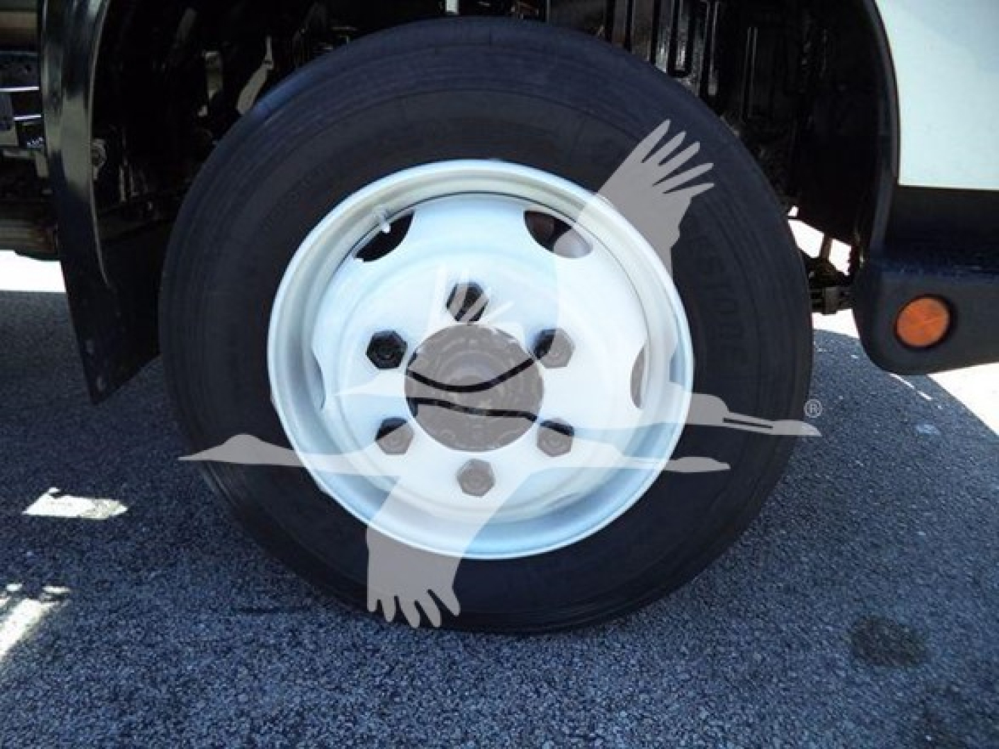 Wheel and tire close-up on a 2020 Hino 195 box truck showing steel rim with five lug nuts and black tire.