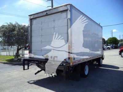 Hino box truck rear/side view showing cargo box with closed roll-up door and rear bumper, used condition.