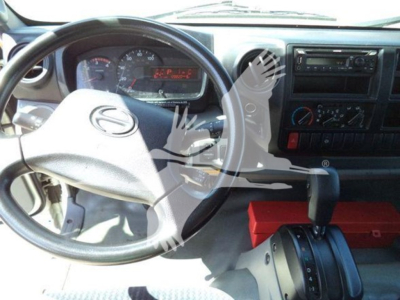 Hino 195 truck interior dashboard and steering wheel with gear shifter and red toolbox visible.