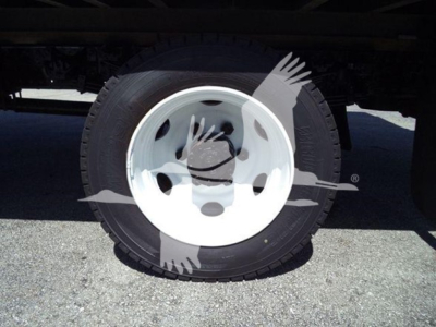Wheel and tire under a truck with white rim and black tire, undercarriage visible