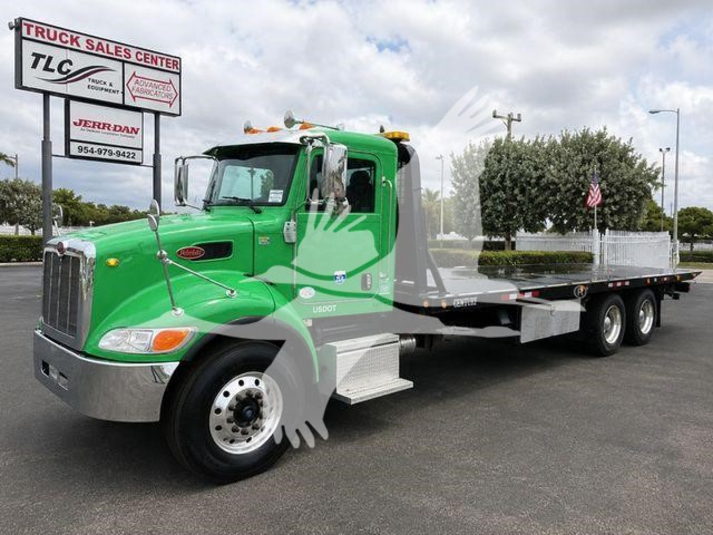 2017 Peterbilt 348 rollback truck in green with flatbed trailer, side view showing chrome bumper, dual rear axles, and TLC Truck Sales Center sign in background.