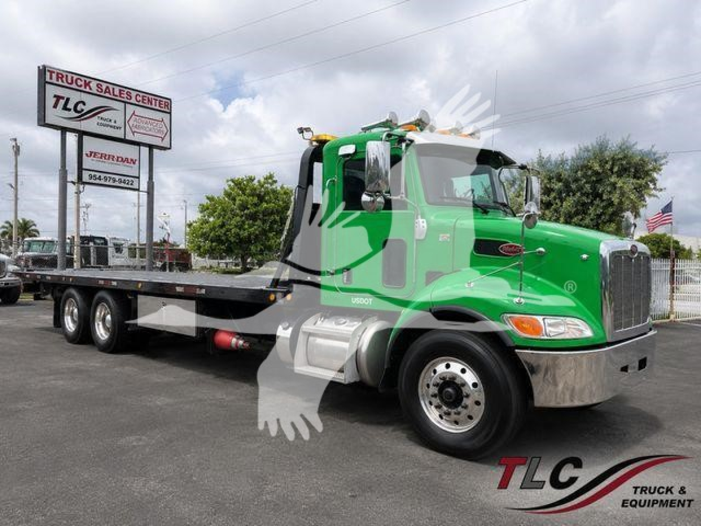 Peterbilt 348 rollback truck with a bright green cab and flatbed, side view, in a dealership lot.