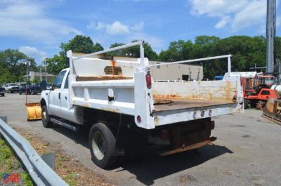 Dump truck bed of a white 2000 Ford F550 Super Duty from rear-left view showing rusty rack sides and tailgate in an equipment yard.