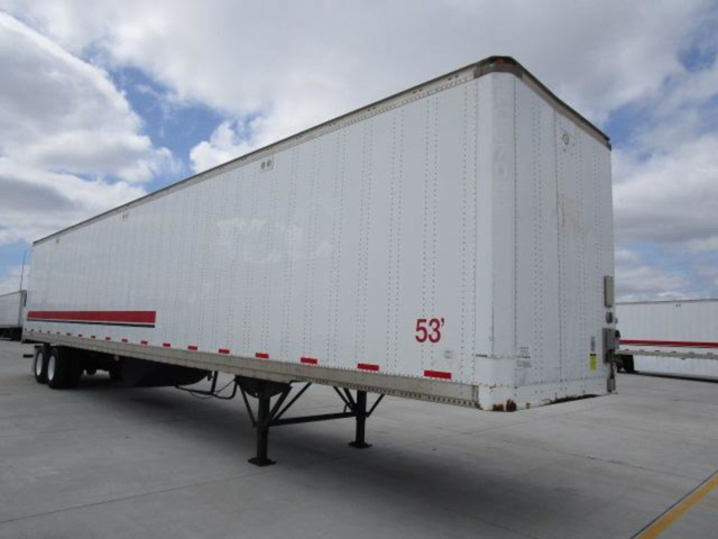 Cargo trailer showing a white Stoughton van with a 53' length marker, raised rear doors, and landing gear in a parking lot.