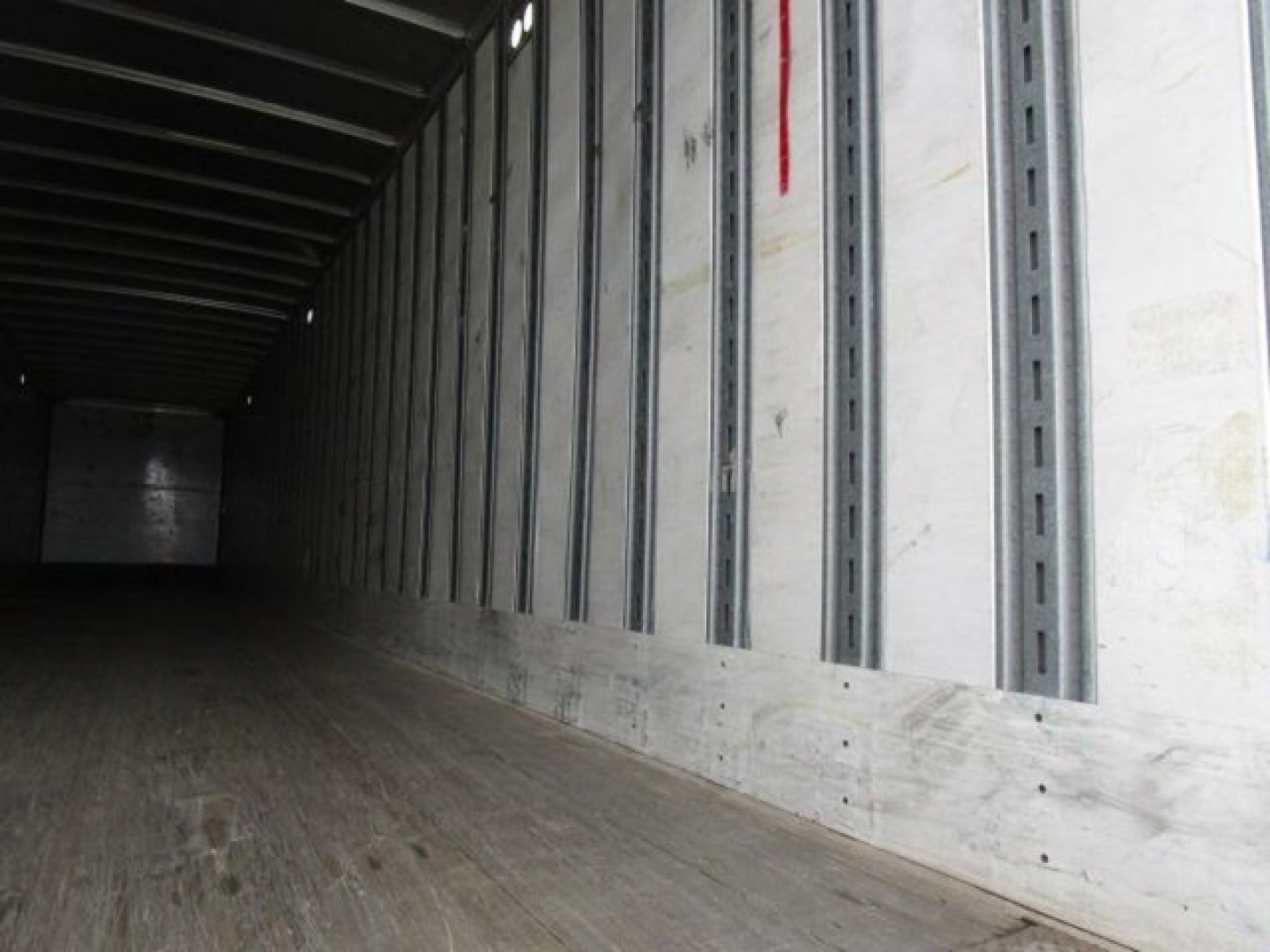 Trailer interior showing wooden floor and metal sidewall rails in a Stoughton van trailer.