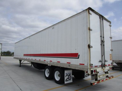 Trailer side and rear of a 2014 Stoughton van trailer showing triple axles, white riveted metal walls, red reflective stripe, and rear double doors with hinges.