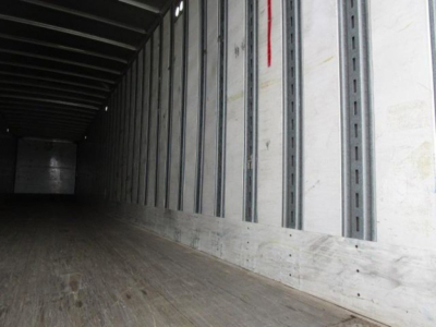 Trailer interior showing wooden floor and metal sidewall rails in a Stoughton van trailer.