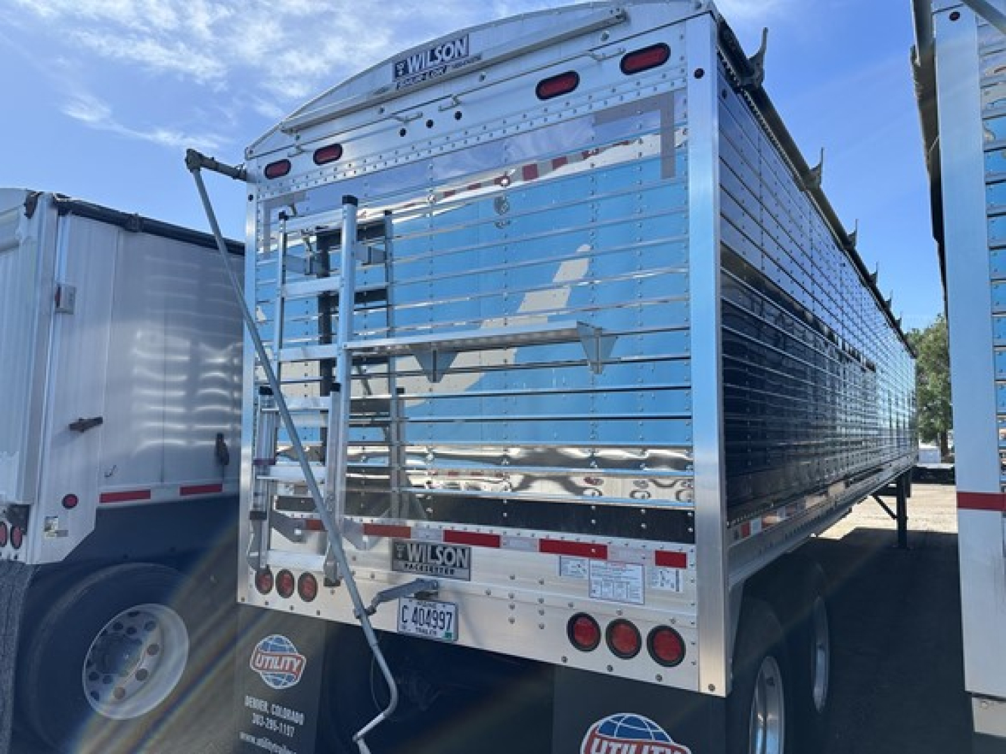 Trailer rear and side view of a 2025 Wilson 42' Air Ride Grain Trailer with 79-inch sides, chrome metal surface, and safety lights.